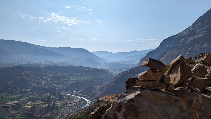 A dramatic landscape view over a valley with layered mountains.