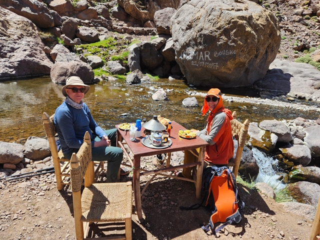 Two people dining by a river.