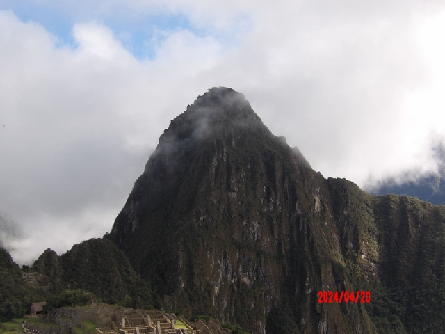       Mountain peak surrounded by mist and clouds.
  