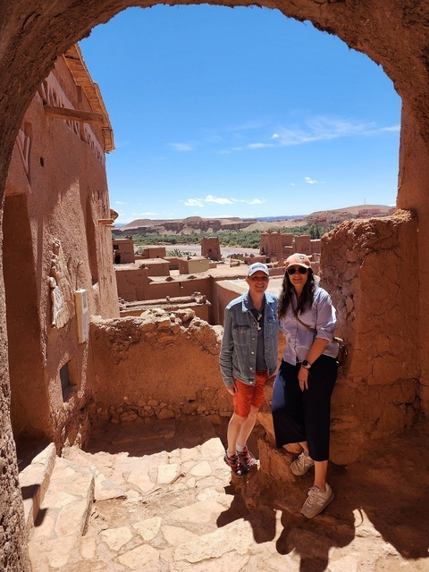      Two people posing in an ancient Moroccan city.
  
