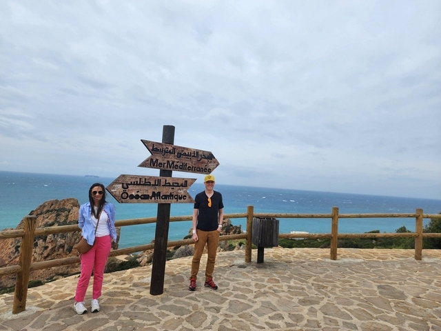 Couple next to a sign indicating direction to the Mediterranean Sea.