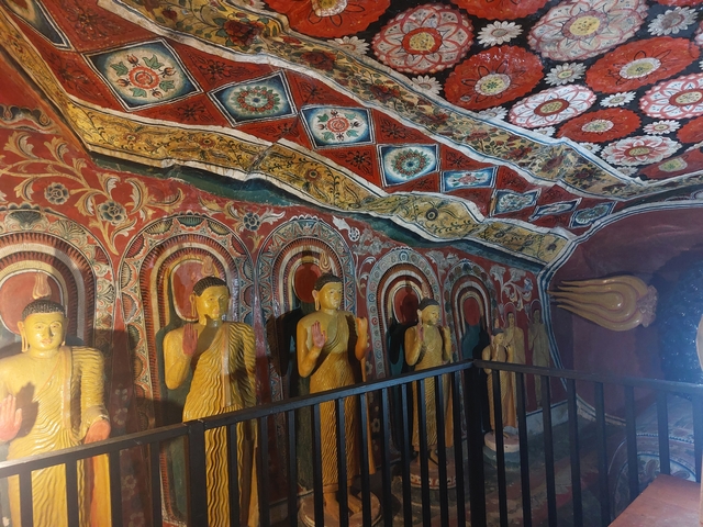       Interior of a temple with colorful statues of Buddha.
  