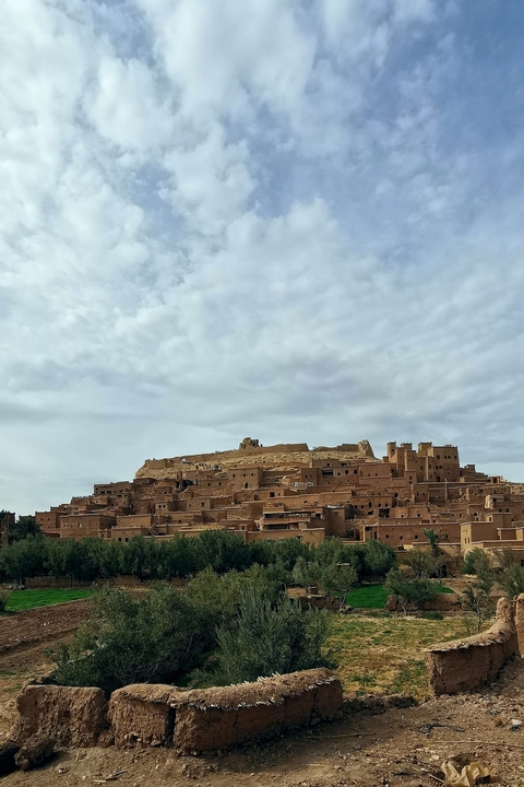 Ancient clay structures under a cloudy sky.