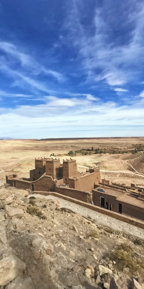 Traditional clay buildings with vast desert landscape.