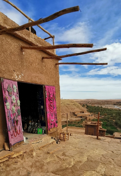 Market stall with jewelry and textiles overlooking a valley.