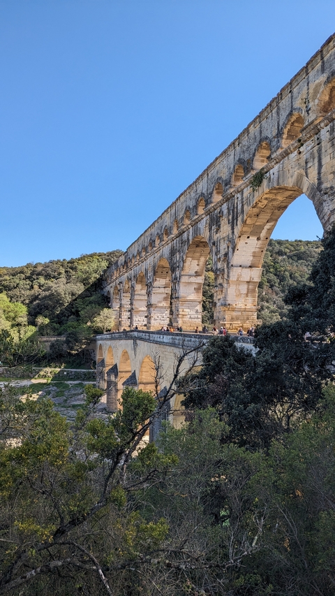 An ancient aqueduct structure amidst greenery.