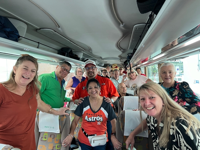       A group of people smiling inside a tour bus.
  