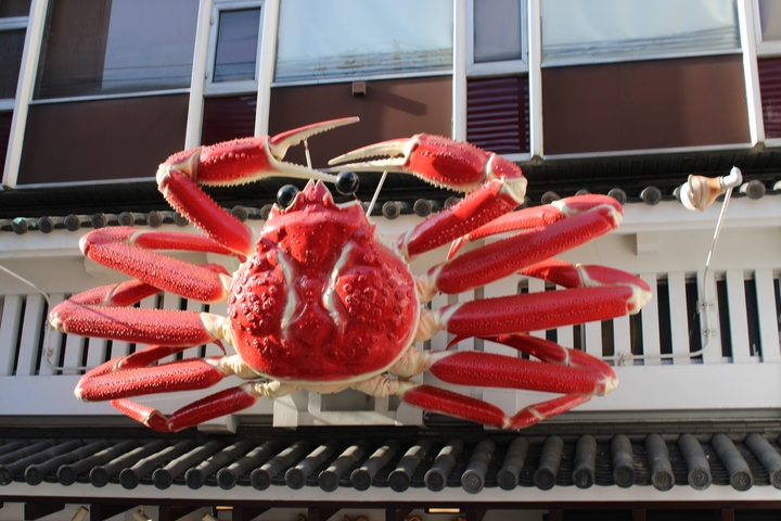       A giant red crab sign on a building facade.
  