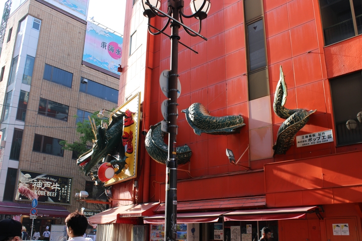       Colorful dragon decoration on a building with a Kobe beef sign.
  
