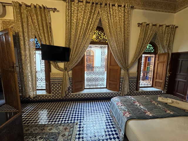       Interior of a decorated room with patterned tiles and windows.
  