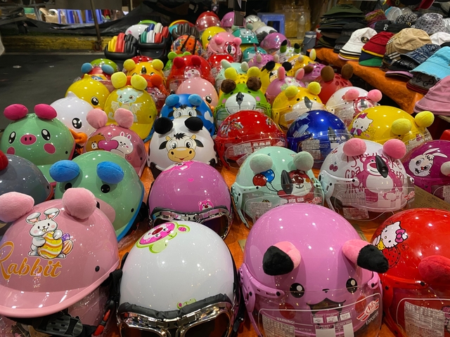 Colorful display of motorcycle helmets with various cartoon designs.