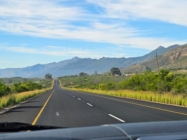       A long stretch of road with mountains in the distance.
  