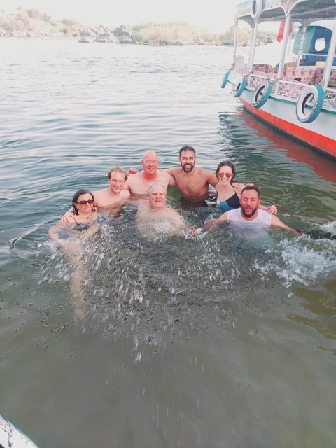       Group of people enjoying swimming in a water body.
  