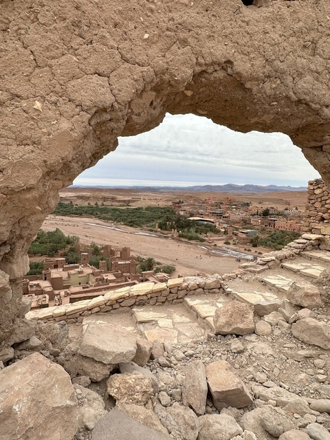 View through a stone archway overlooking an ancient village.