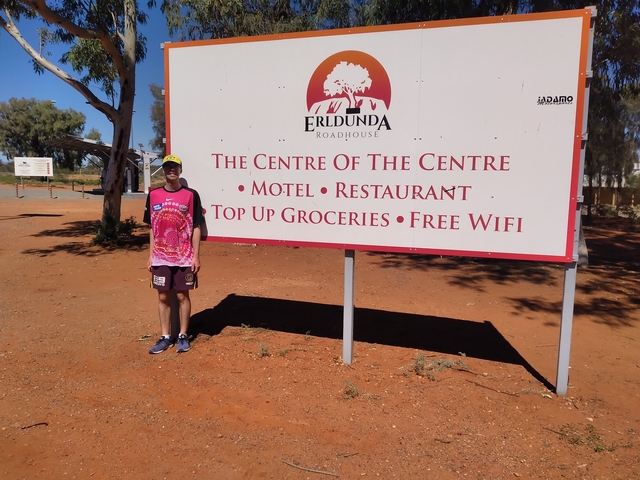 Person standing next to a sign for the Centre of the Centre.