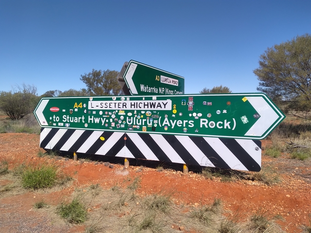       Road sign showing directions to Stuart Highway and Uluru.
  