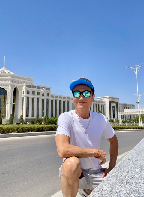 Person posing in front of a grand governmental building.