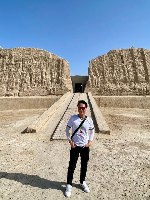      Person standing at the entrance of a historical site.
  
