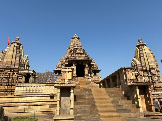 Ancient temple with detailed carvings under blue sky.