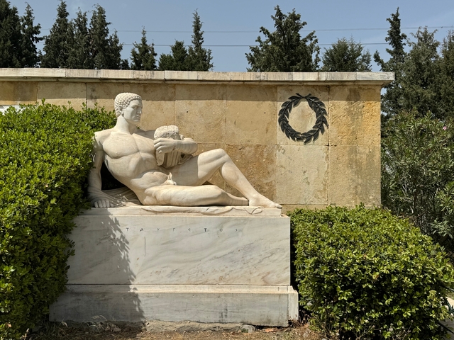       Marble statue of a reclining man with greenery.
  