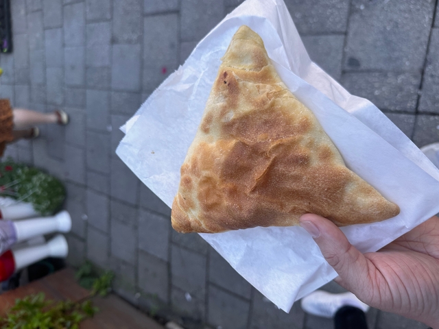 Hand holding a pastry on a napkin.