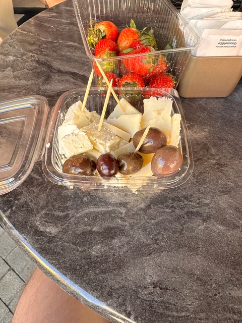 Plastic container with cheese and olives.