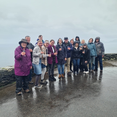       Group of people in rain gear with drinks.
  