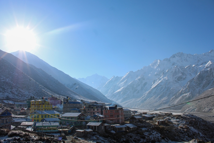Mountain village with snow-covered peaks in the background.