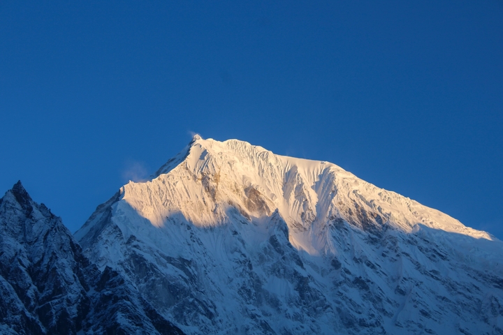 Snow-capped mountain peak against a clear sky.