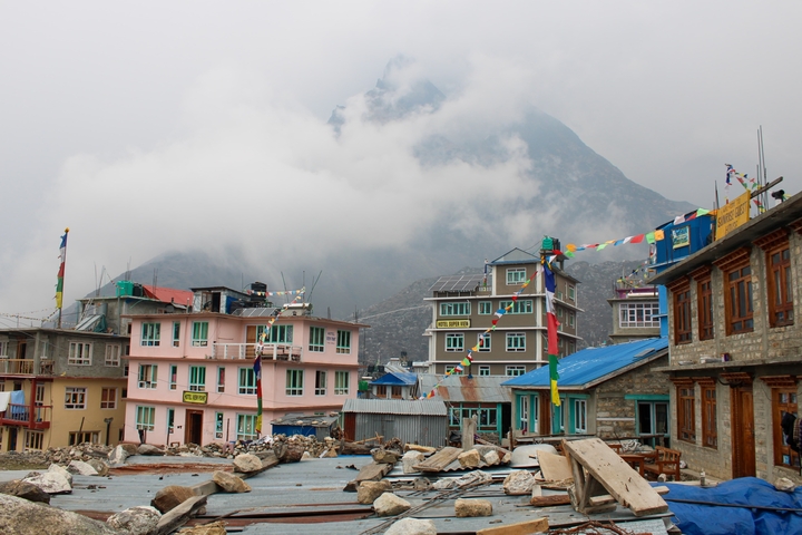 Colorful village buildings with mountain in the background.
