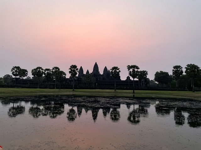 Sunset over Angkor Wat with reflection in the water.