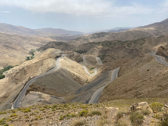 Winding mountain road in a dry, rugged landscape.