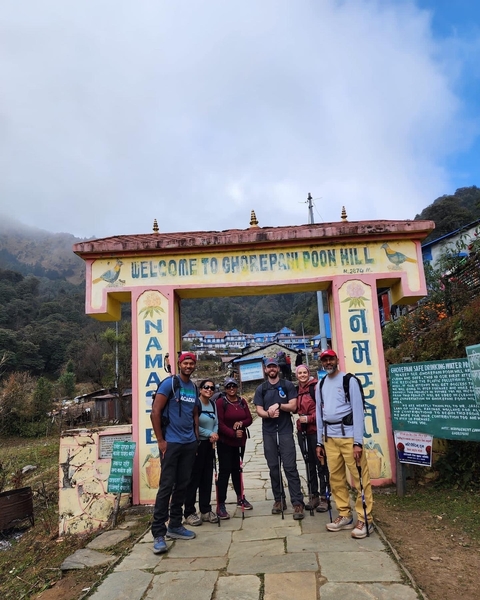 Group of people in front of Ghorepani sign.
