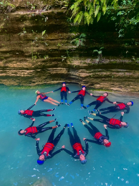       Group of people floating on their backs in a body of water.
  