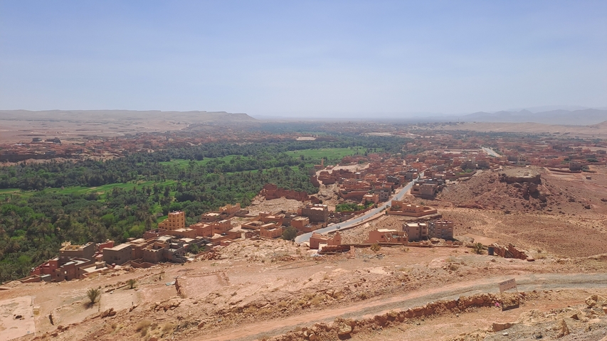 Panoramic view of a sprawling Moroccan town in a desert landscape.