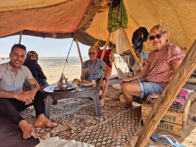       Group of people enjoying a traditional meal in a tent.
  