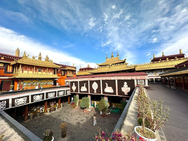 Golden-roofed monastery with clear skies and intricate artwork.