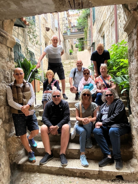 Group of people sitting on stone stairs smiling.
