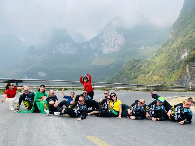 A group of people posing on a mountain road.