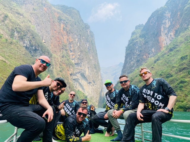 A group of people posing on a boat in a canyon.