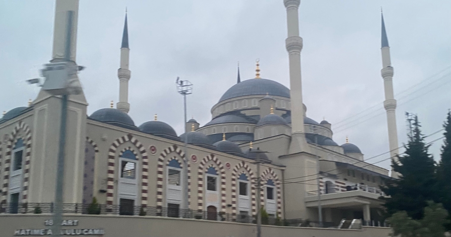 Blurred view of a mosque with multiple domes and minarets.