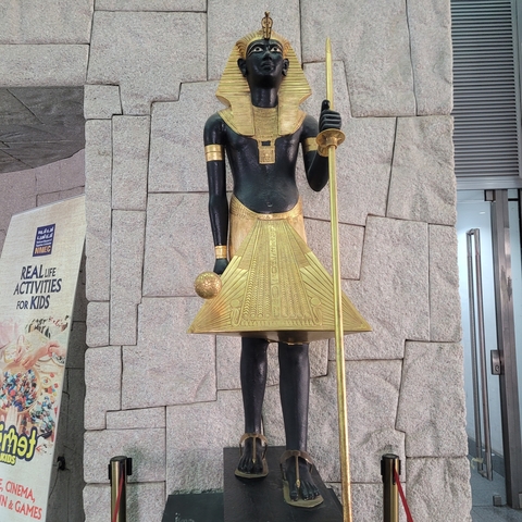 Statue of an Egyptian figure with a staff and an ankh.