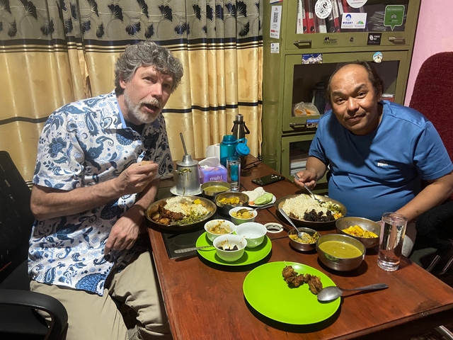 Two people enjoying a meal with a variety of dishes.