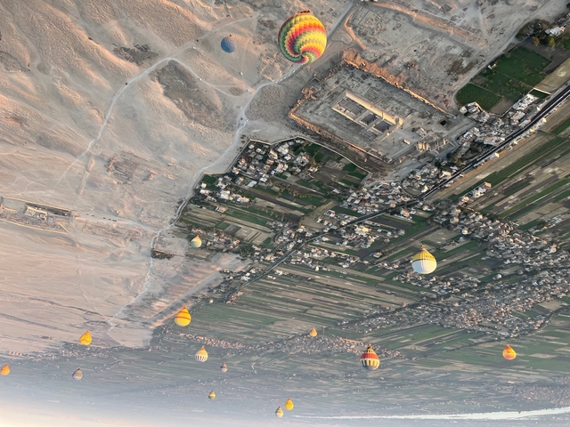 Aerial view of landscape with hot air balloons and fields.