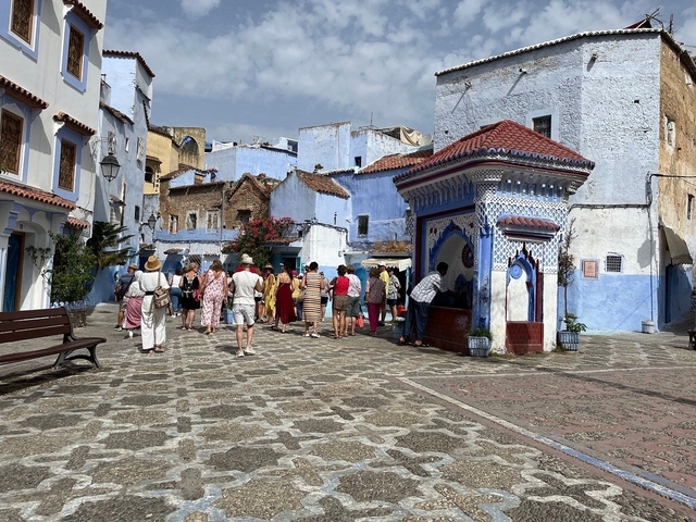 Open market square in Chefchaouen with blue buildings