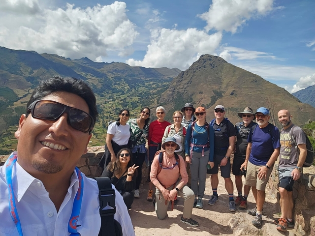 Group of tourists posing with mountains in the background.