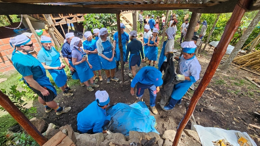 Group of people gathered in a rural outdoor setting for an activity.