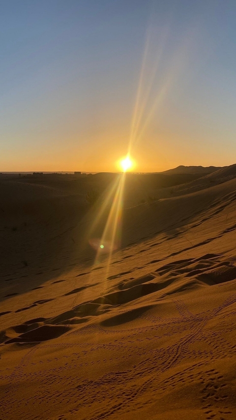       Sunset over sand dunes in the desert.
  