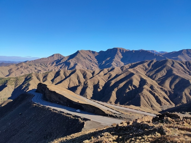       Mountain landscape with winding roads.
  