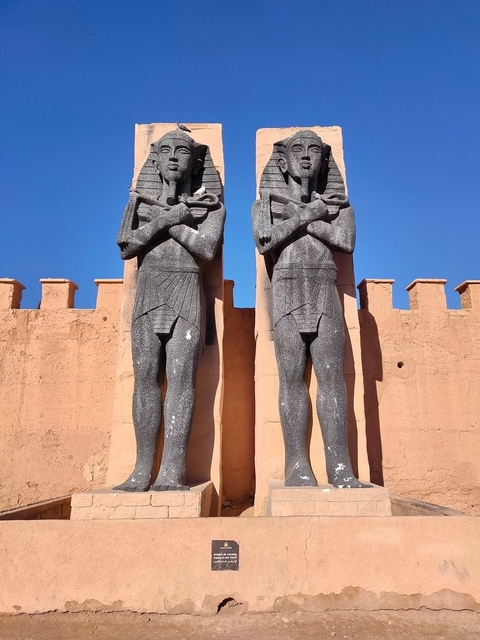       Two large statues at an entranceway.
  